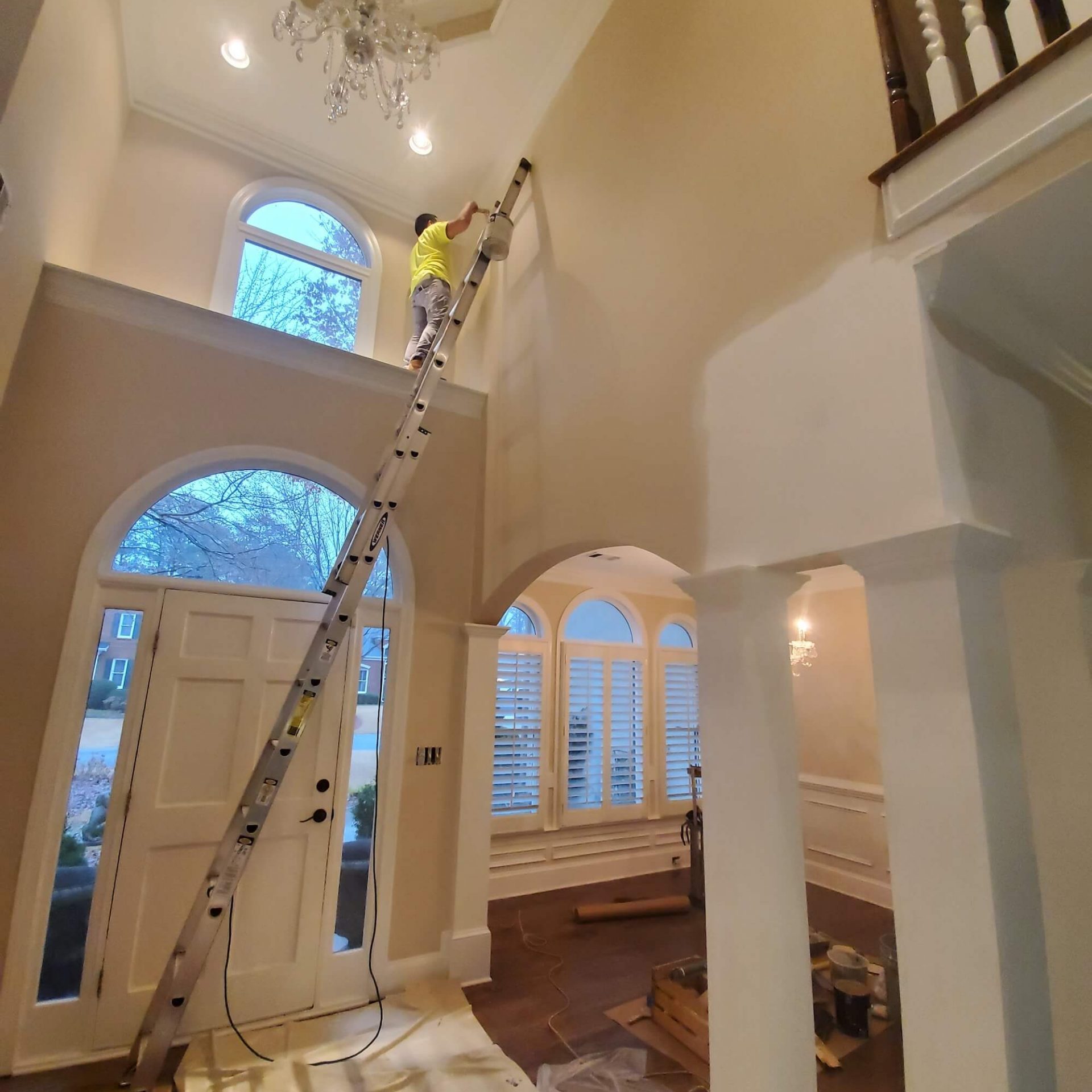 menas quality painting interior paintings working on a ladder painting a foyer with a high ceiling in lawrenceville home